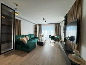 un salon avec un canapé vert et une table dans l'établissement Luxury Avanera Towers Apartments Parking included, à Suceava
