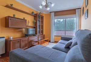 a living room with a couch and a flat screen tv at Vivienda Alló in Rois