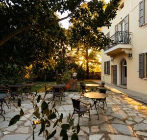 a patio with tables and chairs next to a building at Tuscany Garden Inn - Boutique B&B in Castel San Pietro Terme