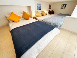 two beds in a room with yellow and blue pillows at Easy go to Hakata and Tenjin, Close to FKK Airport in Itazuke