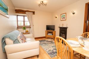 a living room with a dining room table and a fireplace at Ystumgwern Luxury Barn Conversions in Dyffryn