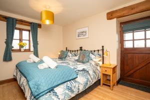a bedroom with a bed and a wooden door at Ystumgwern Luxury Barn Conversions in Dyffryn