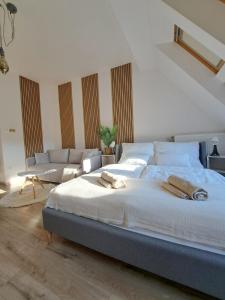 a bedroom with a large bed and a couch at GreenStreetApartment in Kecskemét