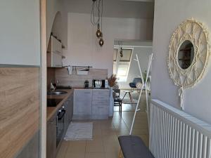a kitchen with a sink and a mirror on the wall at GreenStreetApartment in Kecskemét