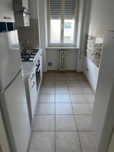 a kitchen with white appliances and a tile floor at Ca Re Dante in Pordenone +4 photos