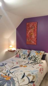 a bedroom with a bed and a purple wall at Retrouvailles de famille et amis 3 étoiles in Lucy-sur-Cure +36 photos
