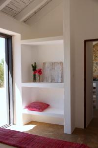 a shelf in a room with a red pillow at Beautiful country home immersed in pine nut farm in São Teotónio +38 photos