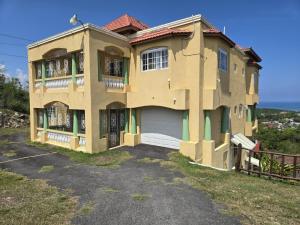 a large house with a driveway in front of it at POINCIANA APARTMENT ONE 257 POINCIANA DRIVE GREEN WOOD MONTEGO BAY JAMAICA in Montego Bay