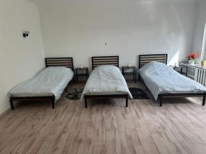 two beds in a room with wooden floors at Haus zur Alten Grube in Bexbach