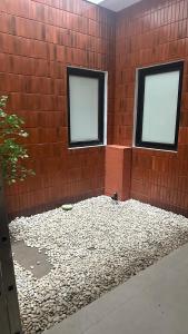 two windows in a brick wall with a bird sitting in it at Cana House Coffee & Stay in Sentool