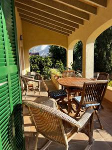 an outdoor patio with a wooden table and chairs at Sa Calma Marina A Tranquil Mediterranean Retreat in Sa Ràpita
