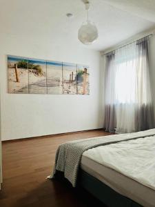 a bedroom with a bed and a painting of the beach at Burgblick Wohnung in Stetten bei Hechingen