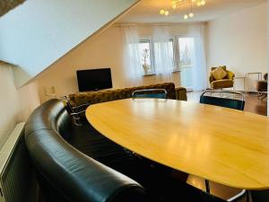 a conference room with a table and a leather couch at Burgblick Wohnung in Stetten bei Hechingen