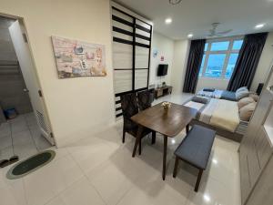 a living room with a table and a bedroom at 4 Pax - Scenic Riverfront Studio B, Kuching City in Kuching