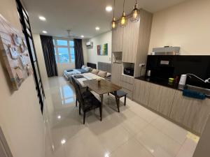 a kitchen and living room with a table and a couch at 4 Pax - Scenic Riverfront Studio B, Kuching City in Kuching