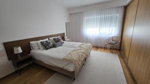 a bedroom with a large bed and a window at Casa Cidade Lagoa - Pool,Jacuzzi family& friends in Rosário-Lagoa +28 photos