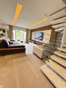 a large living room with a bed and a fireplace at Paraiso na Praia da Enseda in Guarujá