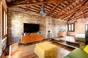 ヴェネツィアにあるGolden Luxe - Glass of Murano luxury apartmentのレンガの壁のリビングルーム(テレビ付)