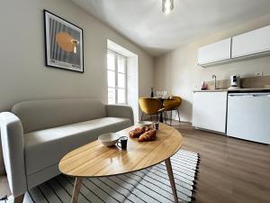 a living room with a couch and a table at E5 Reton T2 chic et confortable au coeur d Epernay in Épernay