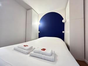 a white bed with two folded towels on it at E5 Reton T2 chic et confortable au coeur d Epernay in Épernay