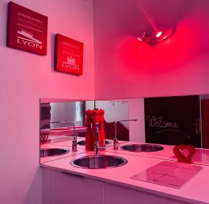 a counter with three sinks in a pink room at Ly'Ove in Lyon