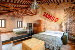 ヴェネツィアにあるGolden Luxe - Glass of Murano luxury apartmentのレンガの壁にベッド1台が備わるベッドルーム1室