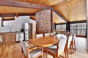 a kitchen and dining room with a wooden table and chairs at The Ski Bungalow - A cozy 2-bedroom retreat in the heart of ski town - Ski and snowboard rental deals! in Killington