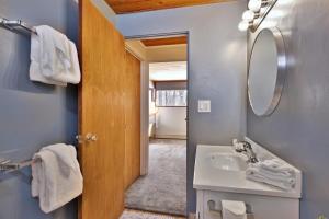 a bathroom with a sink and a mirror at The Ski Bungalow - A cozy 2-bedroom retreat in the heart of ski town - Ski and snowboard rental deals! in Killington +31 photos