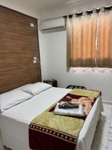 a bedroom with a bed with a blanket on it at New Point Hotel in São Paulo