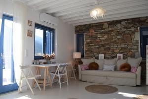 a living room with a couch and a stone wall at Arch House Sifnos in Apollonia