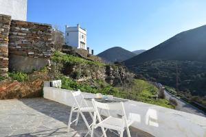 a table and chairs on a balcony with a view of a mountain at Arch House Sifnos in Apollonia
