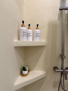 drei Flaschen Toilettenartikel stehen auf Regalen in einem Badezimmer in der Unterkunft High-In Holiday Home&Villa in Ko Phangan
