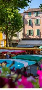 a group of tables with umbrellas in front of a building at Hébergement de vacances à riez à 10 minutes environ du lac de sainte Croix du Verdon in Riez