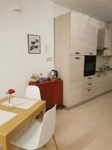 una cucina con un tavolo in legno e mobili bianchi di Era de maggio a Napoli Altre 21 foto