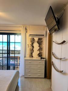 a bedroom with a white refrigerator and a television at Playa de la Fuente in Lajita