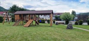 a playground in a yard with a wooden play structure at Casa Tomșa in Rozavlea