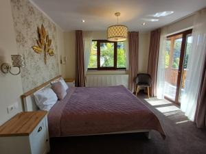 a bedroom with a bed and a desk and a window at Nobila in Sinaia