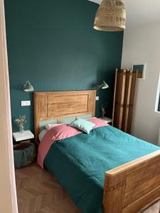 une chambre avec un grand lit avec une tête de lit en bois dans l'établissement charming single-storey house, à Saint-André