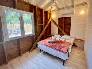 a bedroom in a log cabin with a bed in it at Bungalow cosy à Deshaies avec piscine in Deshaies +14 photos