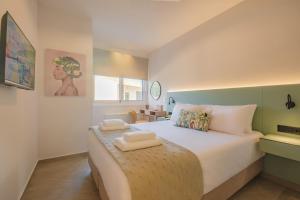 a bedroom with a bed with two towels on it at Olive Garden House in Gastourion