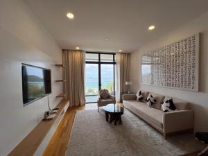 a living room with a couch and a tv at JD Luxury Lavanya Apartment in Pulau Tepur
