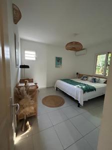 a bedroom with a bed and a tiled floor at Villa cosy toute équipée avec piscine in Le Gosier +10 photos