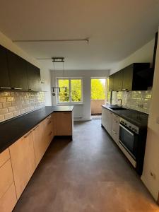 ケムニッツにあるGemütliche, ruhige Wohnung in direkter Uninäheの大きなキッチン(木製キャビネット、黒の電化製品付)