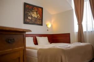 a bedroom with a bed and a painting on the wall at Hotel CENTRAL Balchik in Balchik