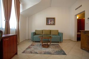 a living room with a couch and a table at Hotel CENTRAL Balchik in Balchik