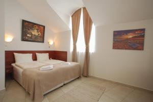 a bedroom with a large bed in a room at Hotel CENTRAL Balchik in Balchik