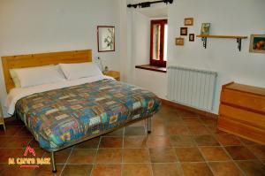 a bedroom with a bed and a tiled floor at Al campo base in Civitella Alfedena