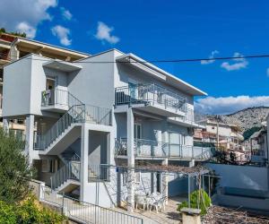 a white building with balconies on the side of it at Apartments Vulić in Omiš