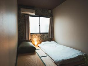 大阪市にある-智 tomo- 難波 天王寺まで約15分 大阪観光に便利な和風宿 無料Wi-Fiのベッドと窓のある小さな寝室