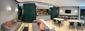 ein Wohnzimmer mit Sofa, Tischen und einer Bar in der Unterkunft Il Palazzin Hotel in St Paul's Bay